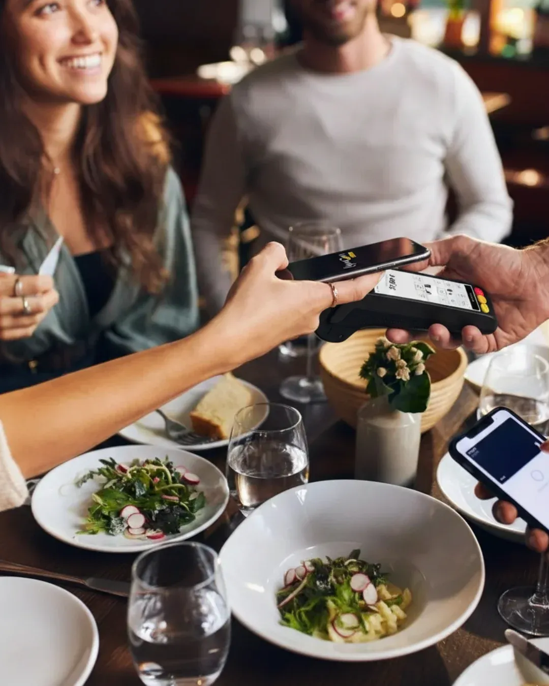 Cliente pagando con tarjeta en la mesa del restaurante